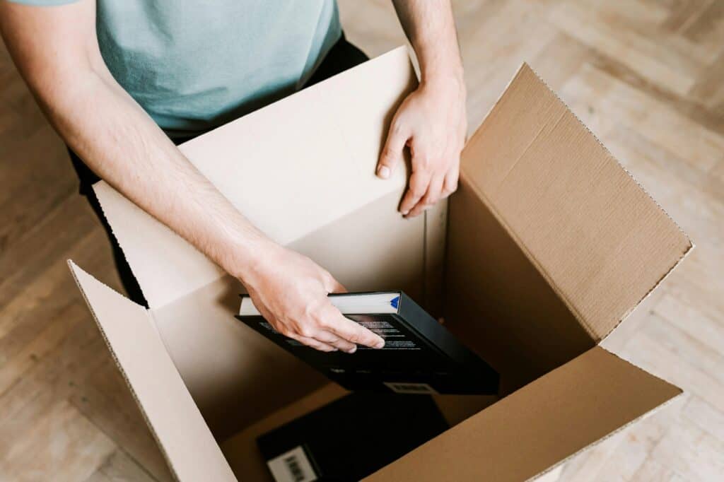 A male student is packing his books for his house move.