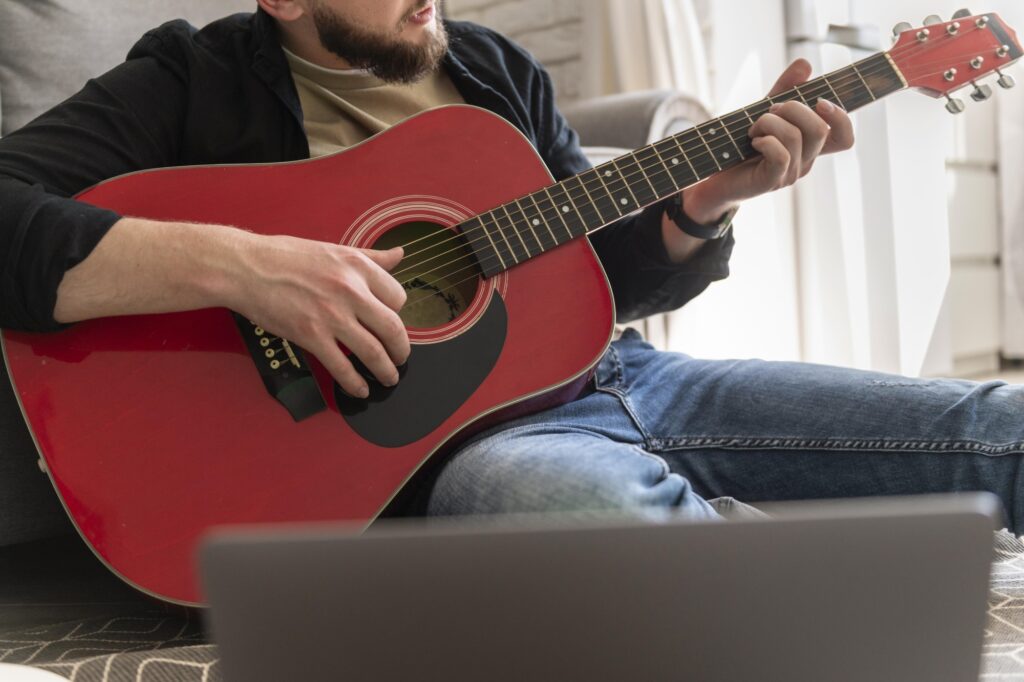 Cropped photo of a man playing the guitar